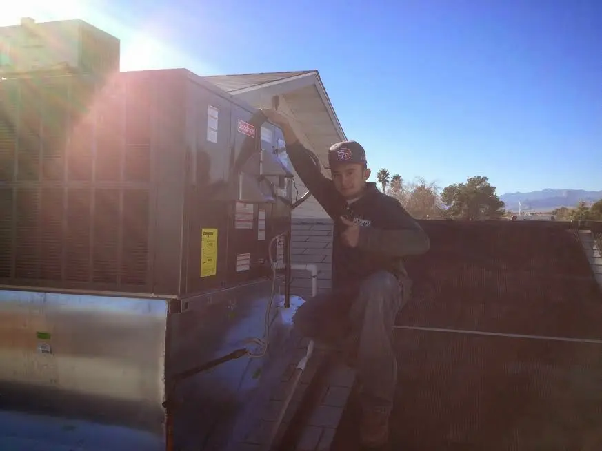 HVAC technician performing Heat Pump Repair on a rooftop unit in North Madison